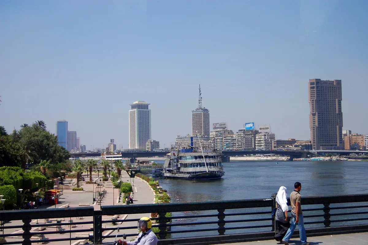 The Nile in central Cairo with high-rise buildings and a river boat, the start of a Nile cruise from Cairo