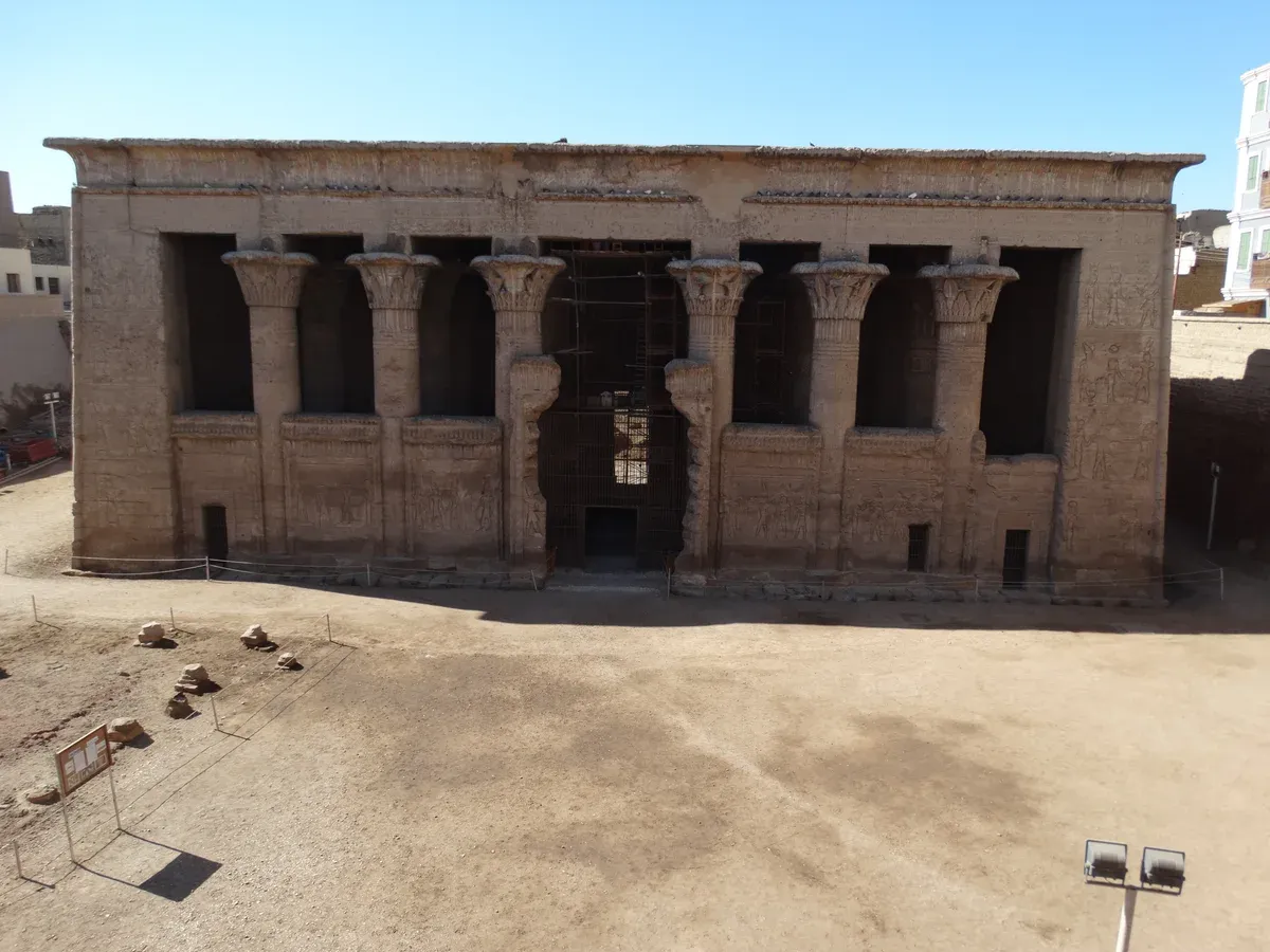 The columned front of the Temple of Khnum at Esna sunk below street level, a stop on a Nile cruise