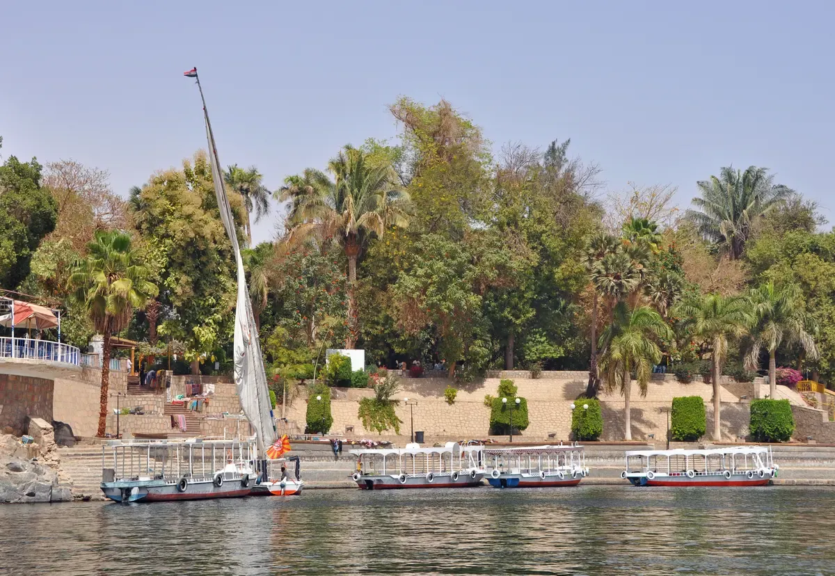 A felucca and boat landing at the palm-covered Kitchener's Island at Aswan on a Nile cruise